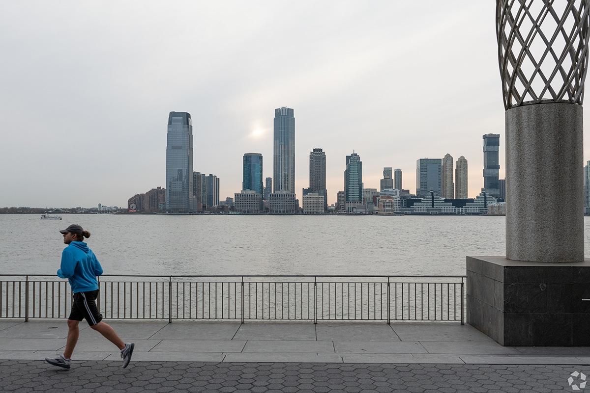 A person is running next to the river in NYC.