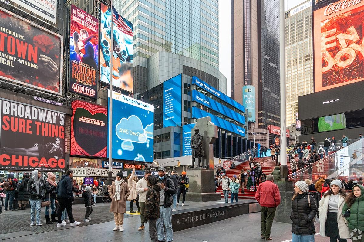 People cluster in Father Duffy Square.