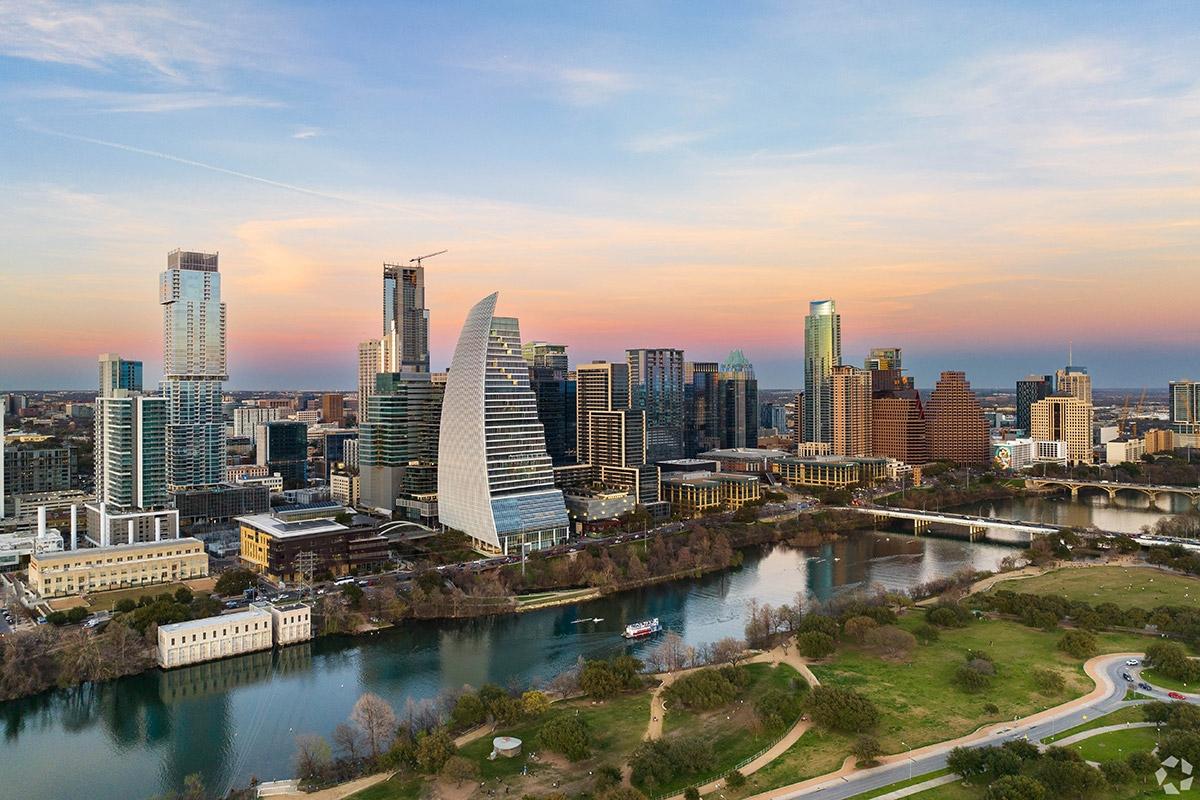 Downtown Austin rises on the riverfront with many tall and architecturally distinct buildings.