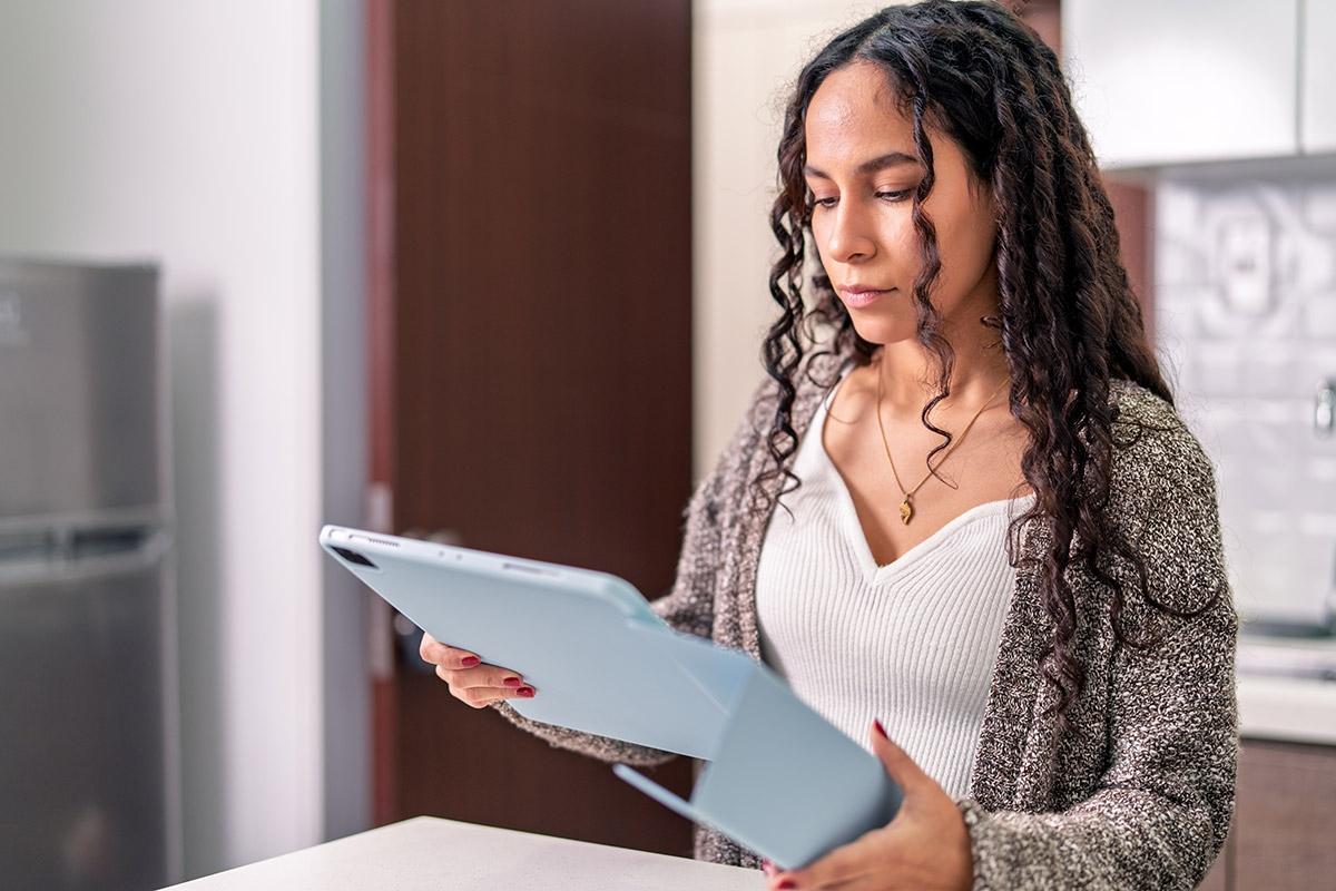 A woman renter reading over lease on tablet.