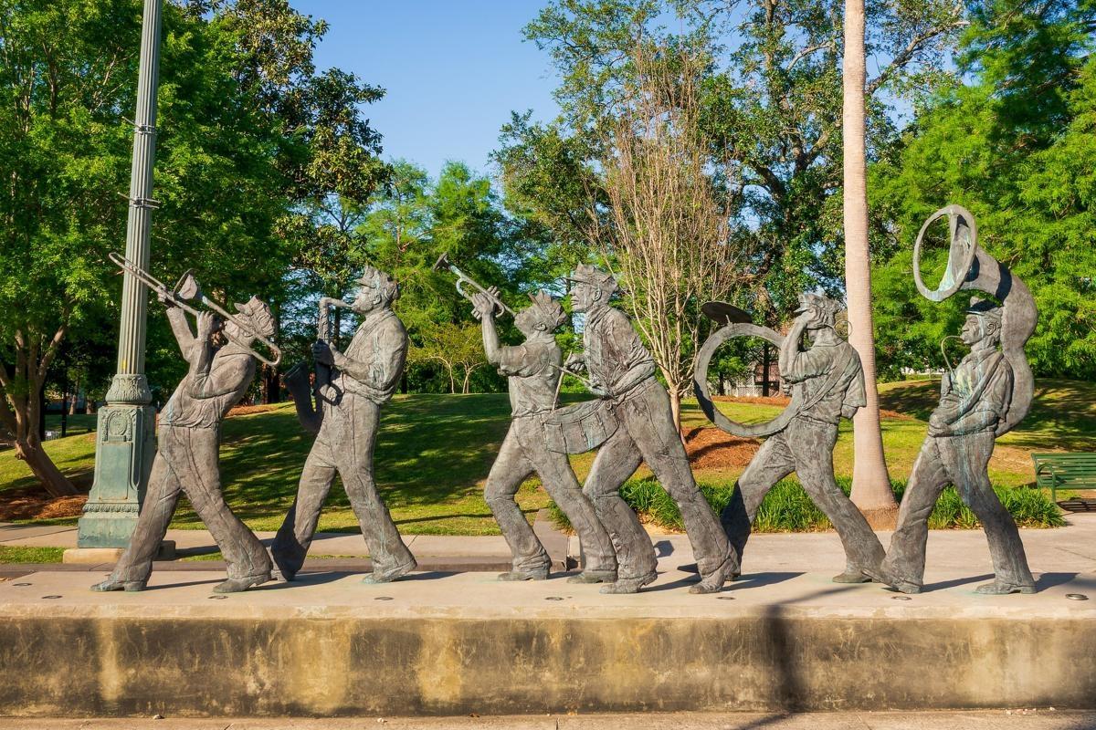A bronze sculpture of a street band marching along in Louis Armstrong Park