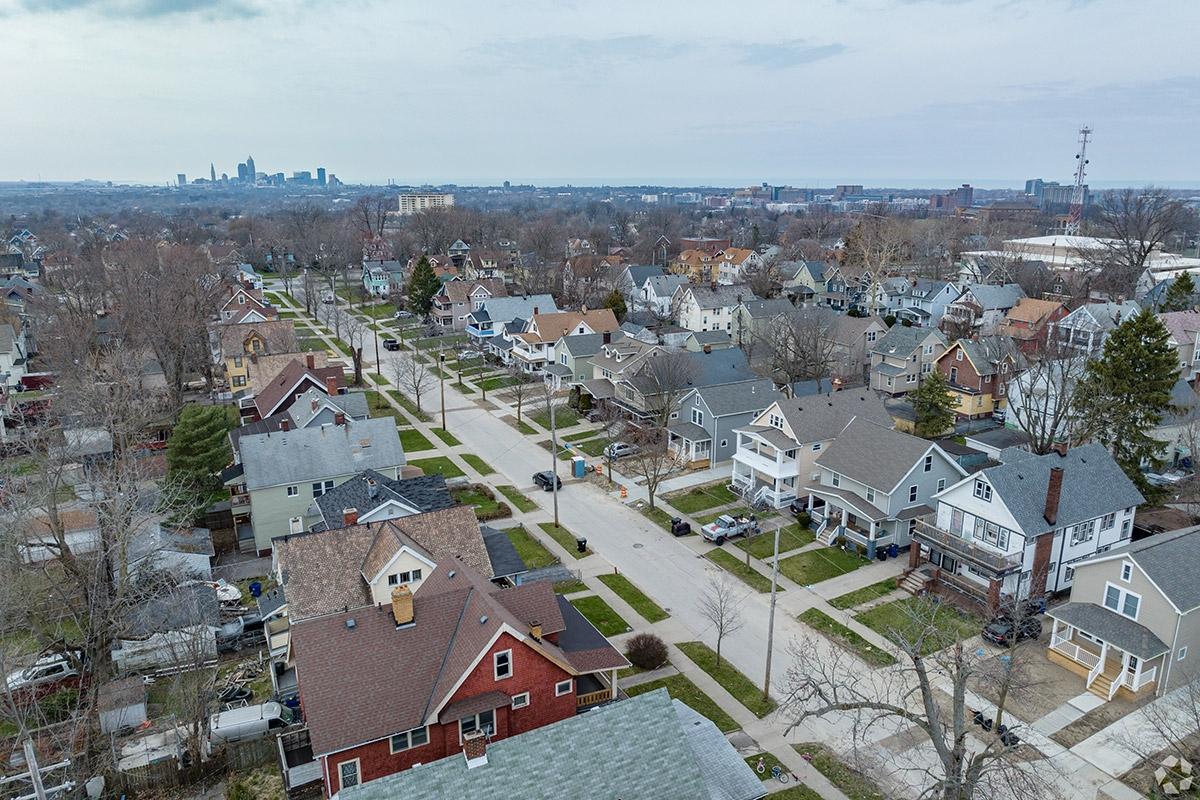 Homes line streets with tree-filled yards in Buckeye-Shaker as downtown rises in the far distance.