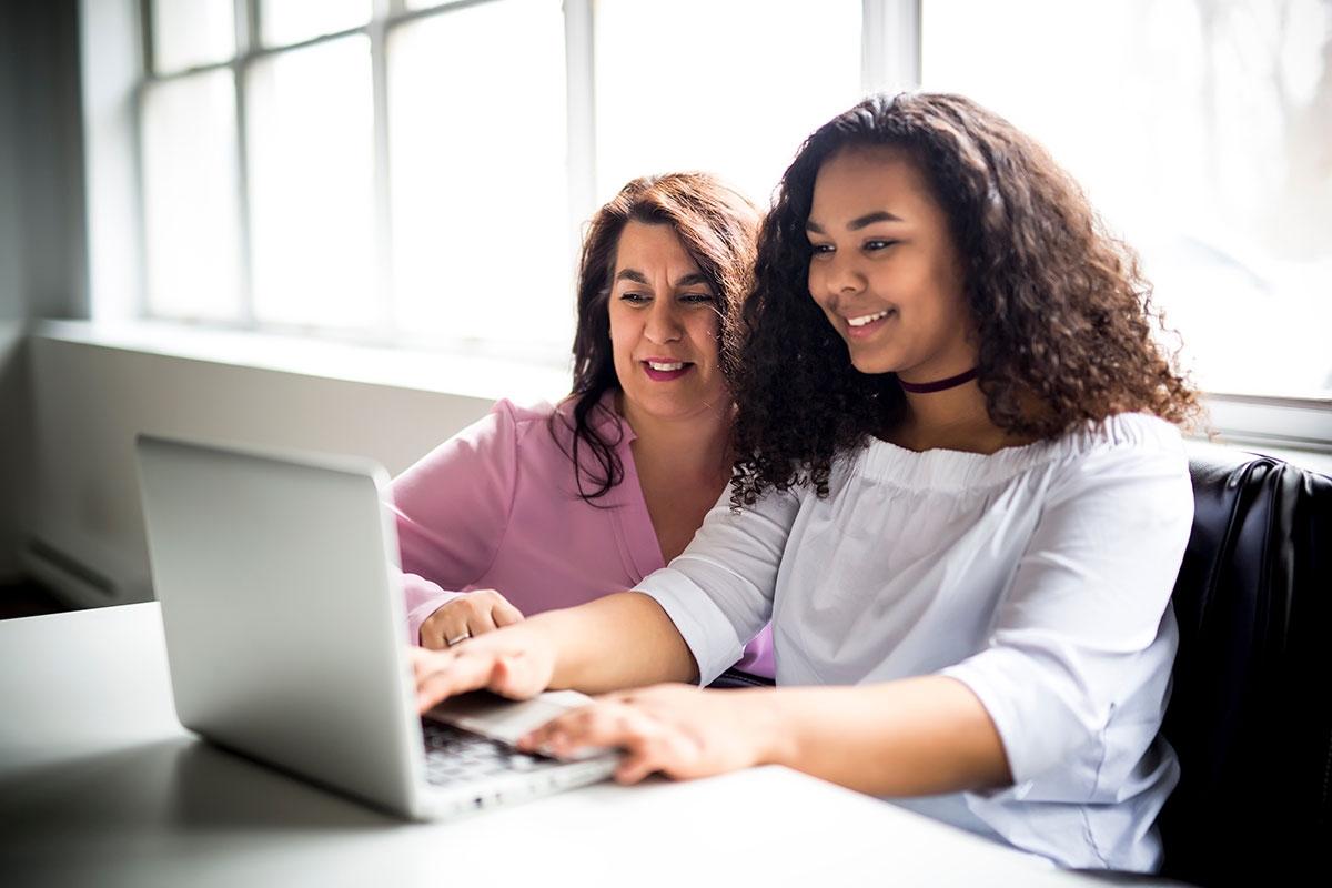 Mom and daughter looking at college tuition costs.