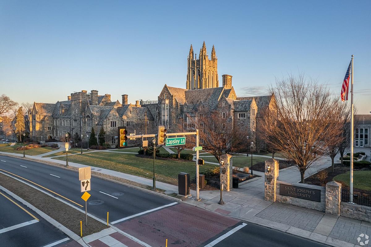 The historic buildings of Saint Joseph's University sit between a stone sign displaying the university's name.