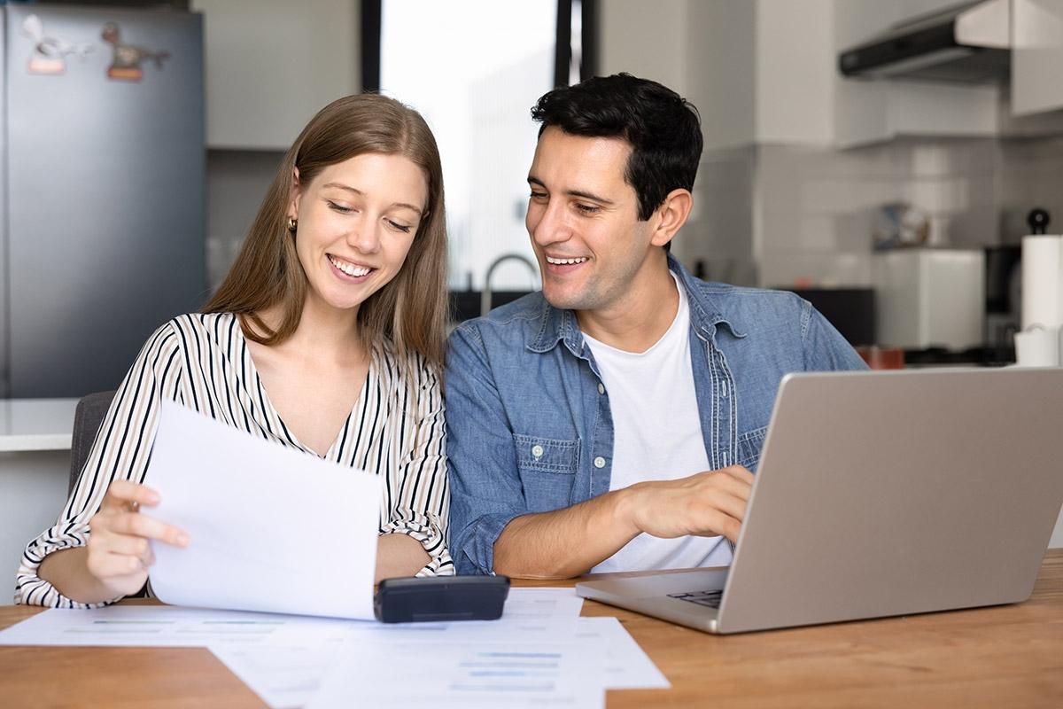 A man and woman reviewing things on paper and a laptop.
