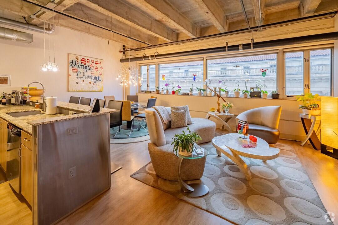 Modern furniture sits inside a loft with exposed concrete.