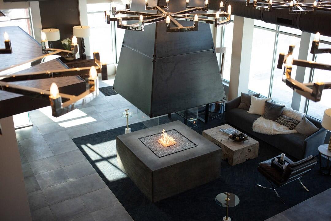 An indoor firepit sits in a lounge with comfy couches for residents to use in a luxury apartment community.