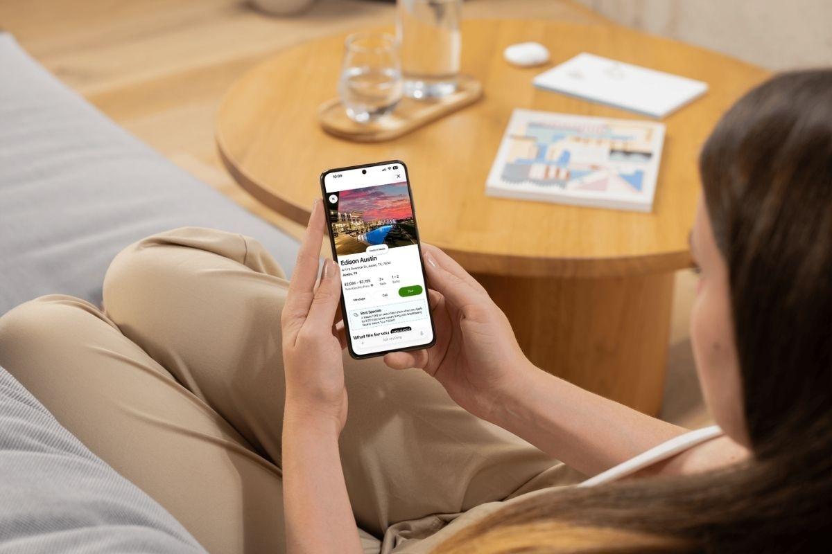 Someone holding a phone and using the Apartments.com ChatGPT app.