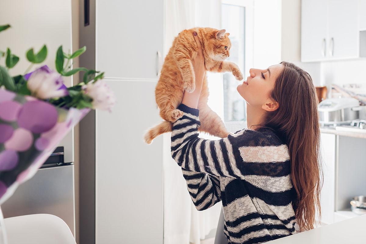 Girl in her apartment holding her pet cat.