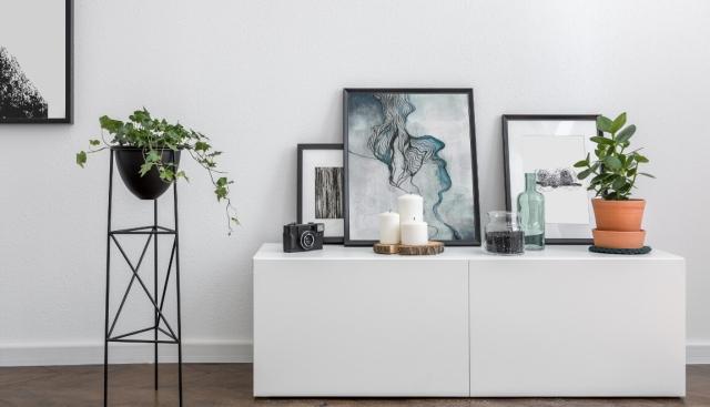 Artwork atop a cabinet leans against the wall.
