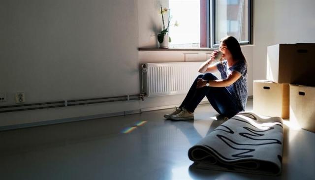 A woman sips coffee after a day of packing.