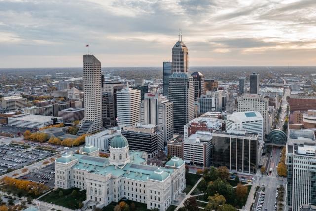 An aerial view of Downtown Indianapolis shows the city’s skyscrapers with the suburbs in the distance.