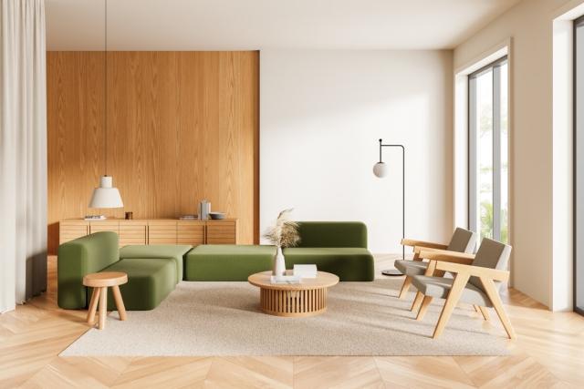 A modern living room has wooden features and green couches.