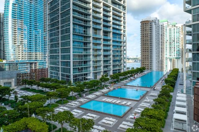 Three rooftop pools are between apartment buildings.
