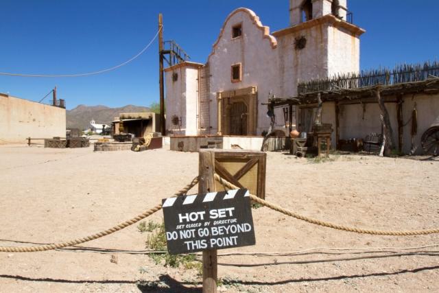 A movie set in the desert is roped off with a sign that reads, "HOT SET: DO NOT GO BEYOND THIS POINT."