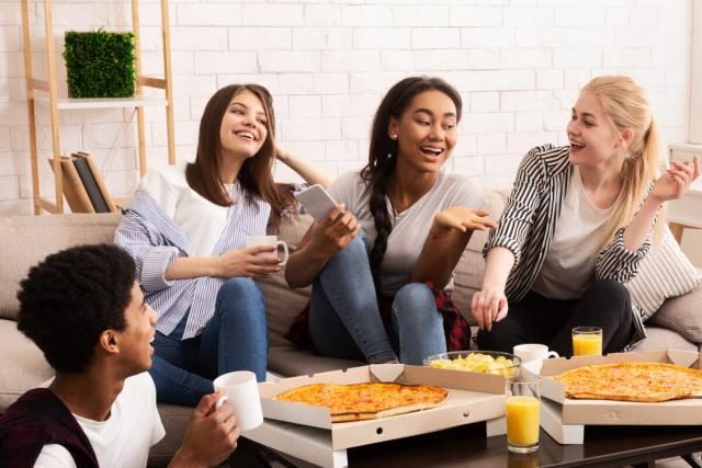 Group of student eating pizza in their apartment.