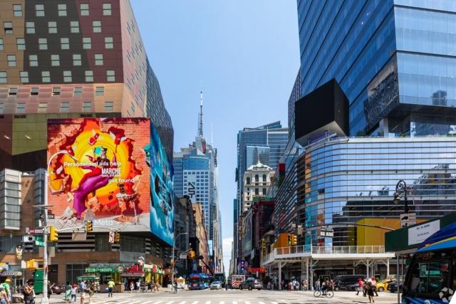 Street-level view of Times Square near Hell's Kitchen with digital billboards, high-rise buildings, and active foot traffic, ideal for city apartment seekers