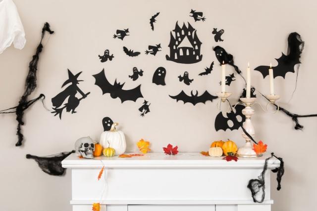 Black Halloween stickers on the wall above a fireplace.