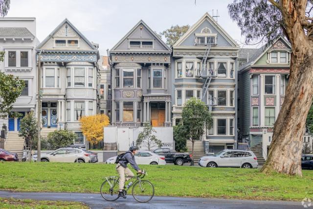 A resident cycles past the iconic Victorian homes near Alamo Square.