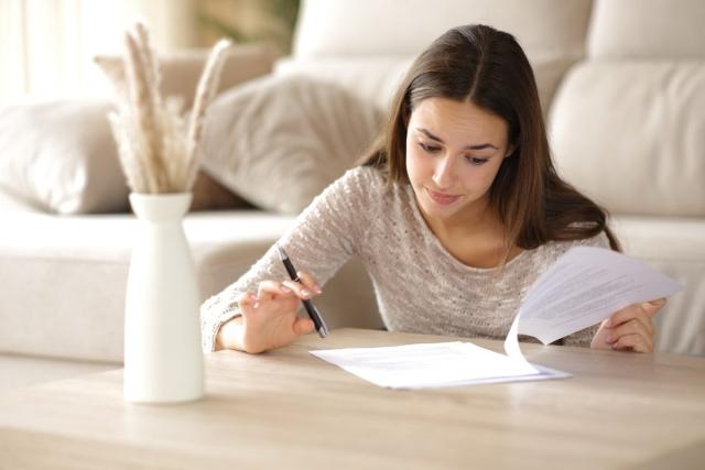 Renter reading a lease agreement with a pen in hand