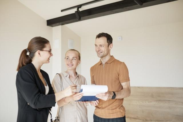 A young couple talks with a property manager while touring an apartment.