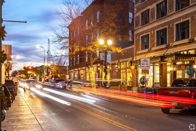 Cars drive by a small town downtown.