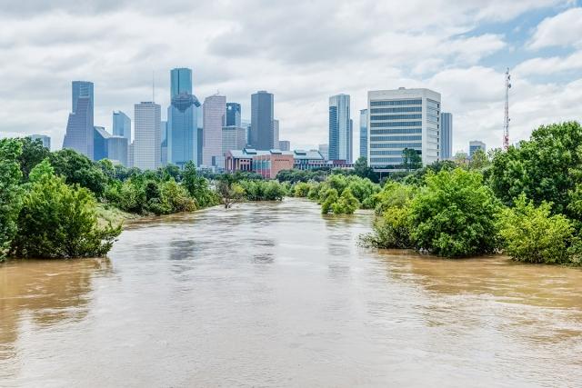 A very flooded river with a major city in the background.