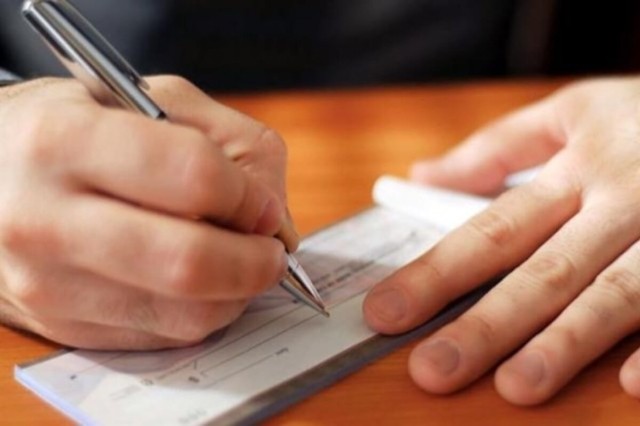 A person fills out a check for their landlord.