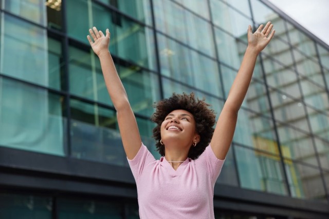 Happy person with arms raised in the fresh outdoor air