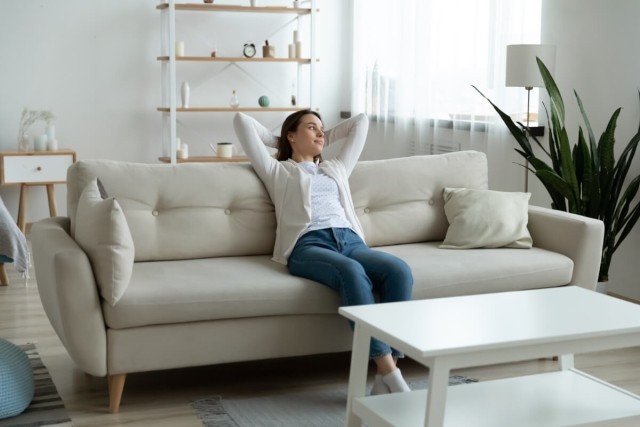 Lady sitting on sofa looking out a window