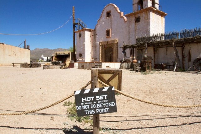 A movie set in the desert is roped off with a sign that reads, "HOT SET: DO NOT GO BEYOND THIS POINT."