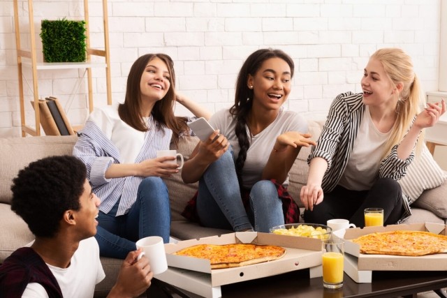 Group of student eating pizza in their apartment.