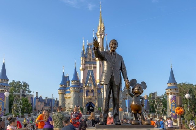 Bronze statue of Walt Disney and Mickey Mouse in front of Cinderella Castle at Magic Kingdom, a top tourist destination for families and apartment renters near Orlando.