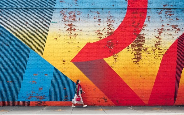 Resident walking in front of a large street mural