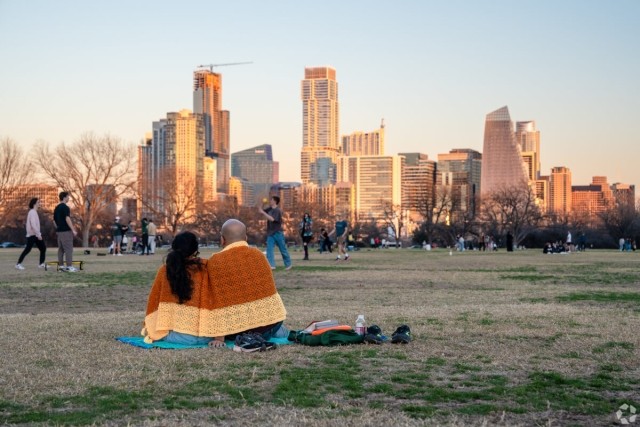 Couple sits in Zilker Park in Austin, TX.