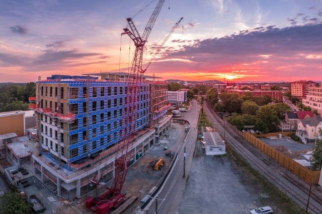 Apartment building being built during sunset.