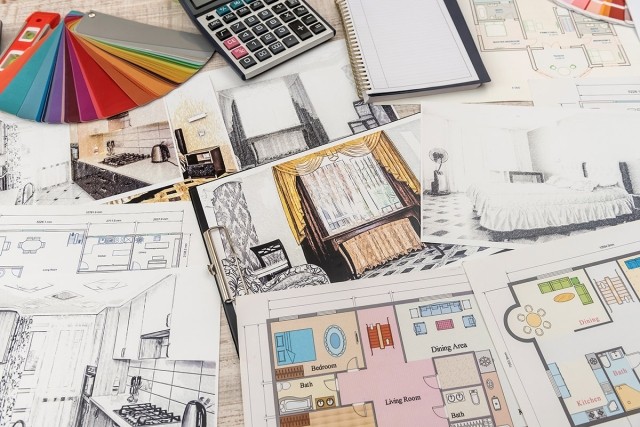 Floor plans, design tools, and room design inspiration pictures spread out on a table.
