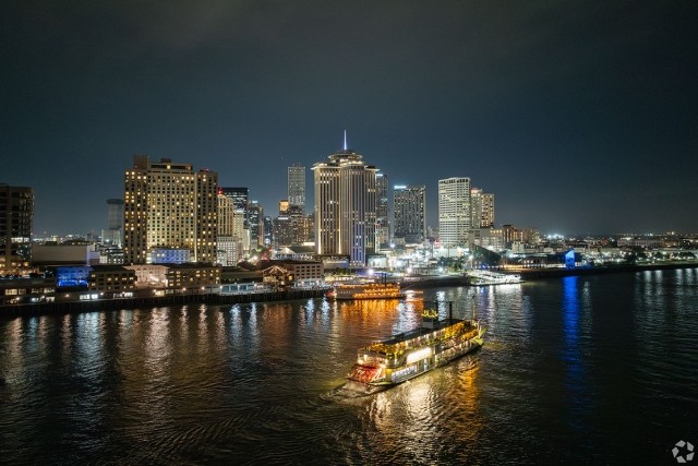 Downtown New Orleans lights up the Mississippi River at night.