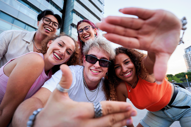 Group of Gen Z renters taking a picture with a big city in the backdrop