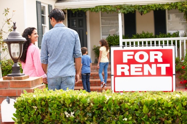 Family standing in front of a home for rent.