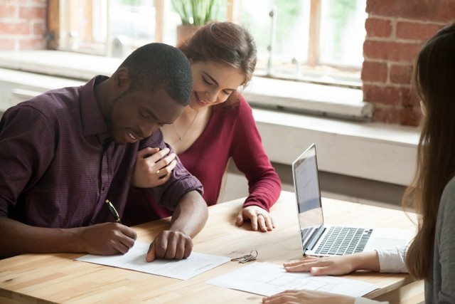 Renters signing a lease with their leasing agent.