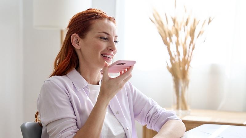 Woman holds up phone and speaks into it