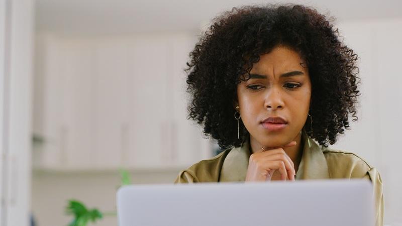 Woman looking at computer with frustrated expression