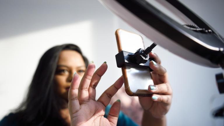 Woman sets up smartphone camera to record a video