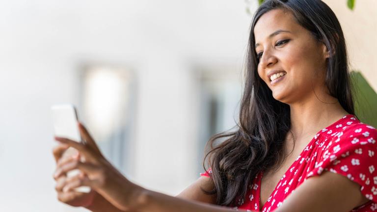 Woman smiles into her smartphone