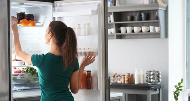woman opening fridge