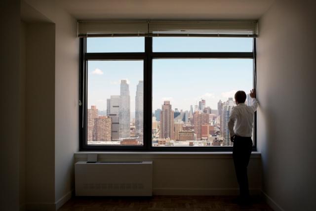New York renter stares outside of their window.