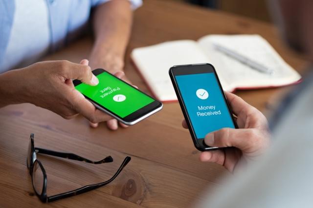 Two people sending money to each other via phone.