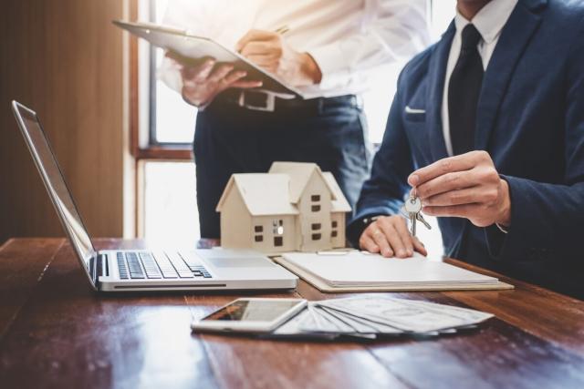 Person handing key after a real estate deal.