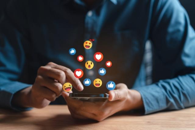 Man scrolls on social media platforms on his mobile device.